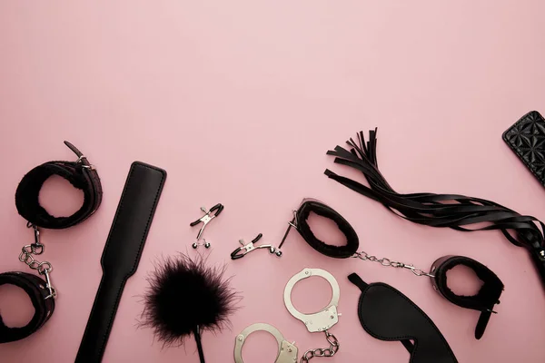 Вид зверху чорних секс-іграшок на рожевому фоні — стокове фото