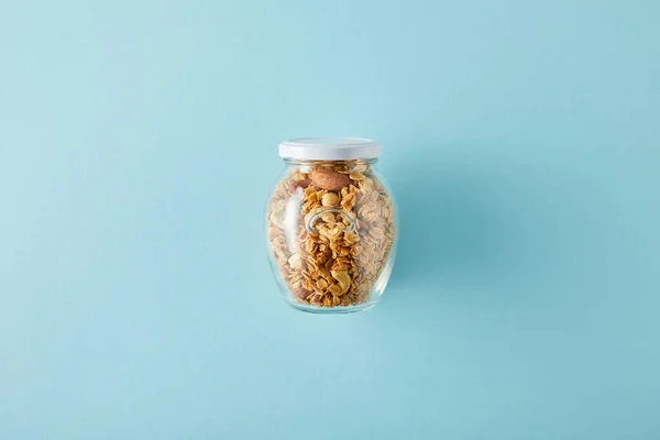 Top view of jar of granola on blue background — Stock Photo