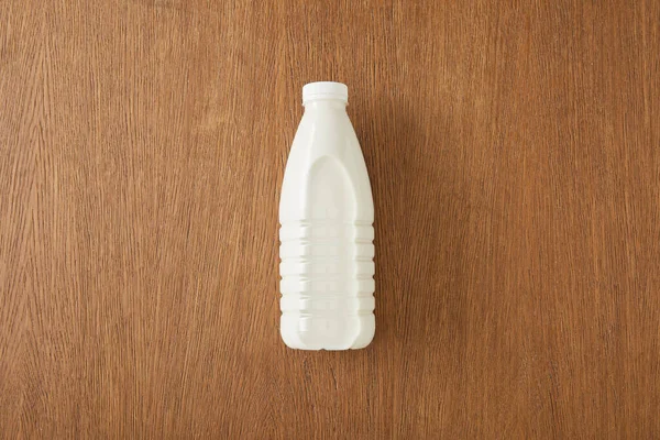 Vista superior de la botella de leche sobre fondo de madera - foto de stock