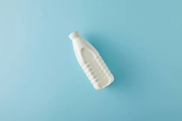 Draufsicht auf eine Flasche Milch auf blauem Hintergrund — Stockfoto