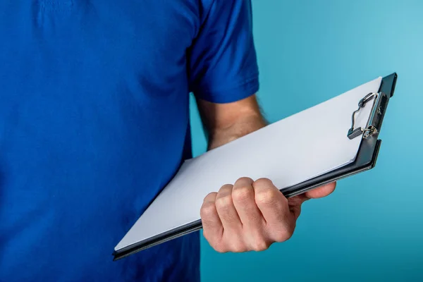 Cropped view of delivery man holding clipboard isolated on blue — Stock Photo
