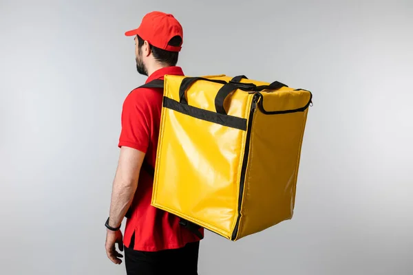 Side view of courier with thermo backpack isolated on grey — Stock Photo