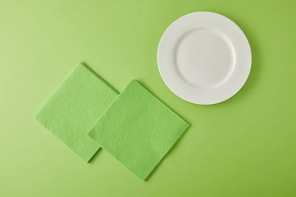 Top view of white plate and rags for dish washing on green — Stock Photo