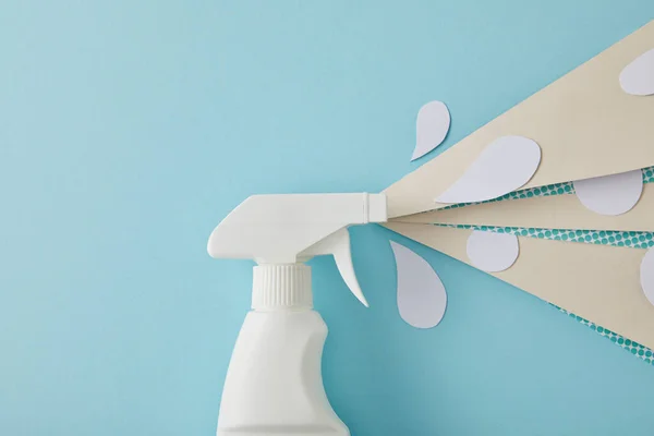 Composition with spray bottle and white water drops made of paper, on blue — Stock Photo