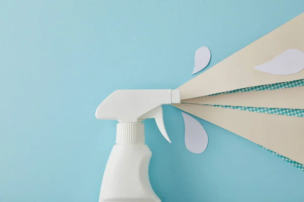 Composição com garrafa de spray de limpeza e gotas de água branca feitas de papel, em azul — Fotografia de Stock