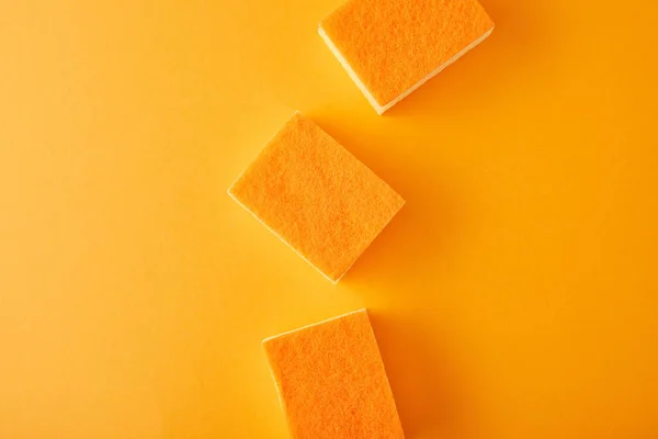 Vue de dessus des éponges pour le lavage des plats sur orange — Photo de stock