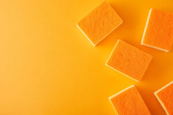 Top view of orange sponges for dish washing on orange — Stock Photo