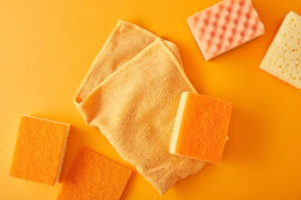 Vista superior de pano e esponjas para limpeza da casa em laranja — Fotografia de Stock