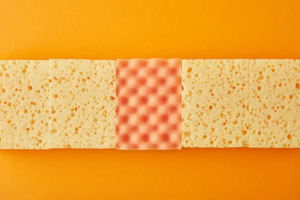 Top view of yellow and orange sponges for house cleaning  on orange — Stock Photo