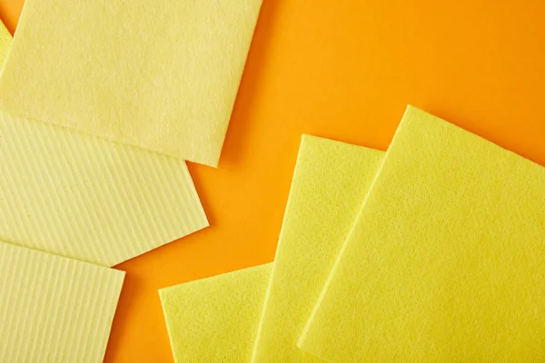 Top view of yellow rags for house cleaning on orange — Stock Photo