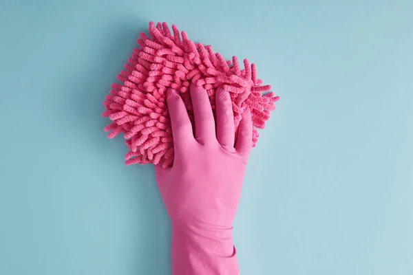 Cropped view of housekeeper in rubber glove holding pink rag on blue — Stock Photo