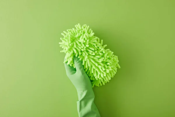 Top view of housekeeper in rubber glove holding rag on green — Stock Photo