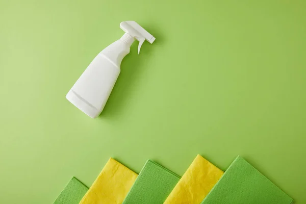 Vista superior de trapos e frasco de spray para limpeza da casa em verde — Fotografia de Stock