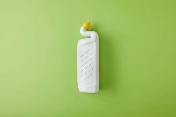 Vista superior de la botella blanca con limpiador de inodoro en verde - foto de stock