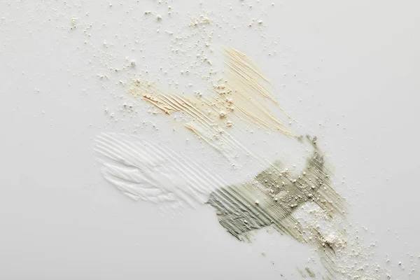 Вид зверху глина, косметичні та тонкі кремові мазки на сірому — стокове фото