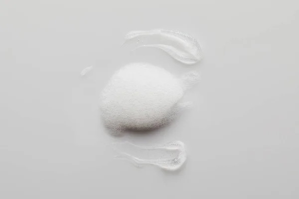 Vue du dessus des coups de pinceau en gel avec mousse de savon sur fond gris — Photo de stock