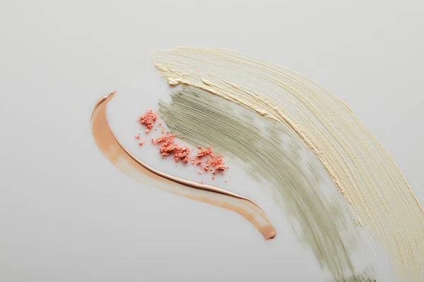 Vue du dessus de la crème tonique et des coups de pinceau en argile cosmétique avec blusher sur fond gris — Photo de stock