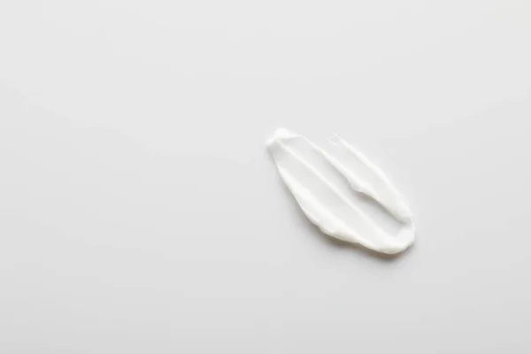 Top view of cosmetic cream brushstroke on grey — Stock Photo