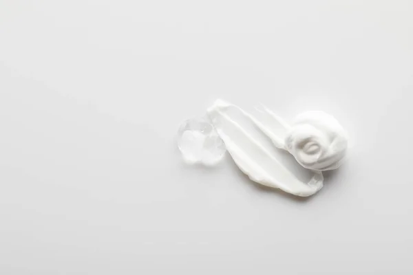 Vista superior de pinceladas de crema cosmética con gel sobre fondo gris - foto de stock