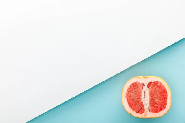 Вид зверху на половину грейпфрута на синьо-білому фоні — стокове фото