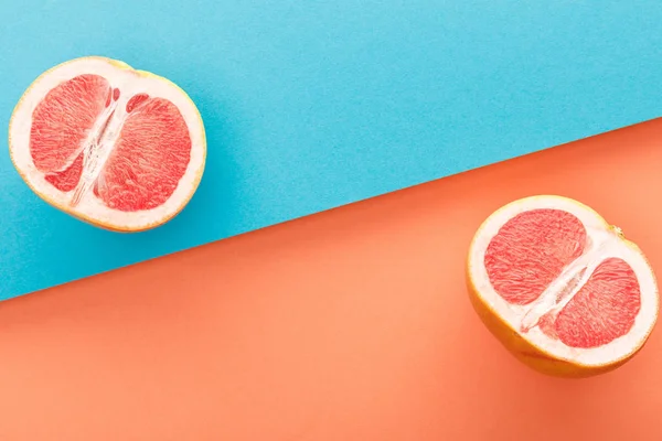 Top view of grapefruit halves on blue and orange background — Stock Photo