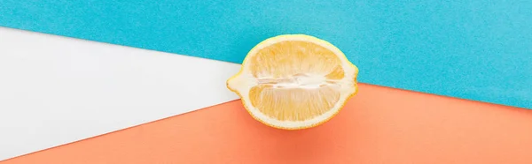 Top view of lemon half on blue, orange and white background, panoramic shot — Stock Photo