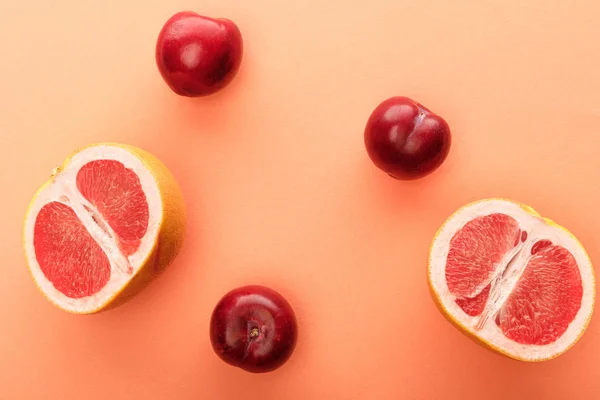 Vista superior de manzanas y mitades de pomelo sobre fondo blanco y naranja - foto de stock