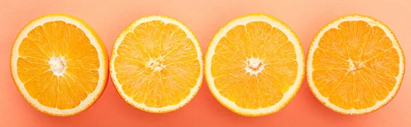 Top view of citrus fruits halves on orange background, panoramic shot — Stock Photo