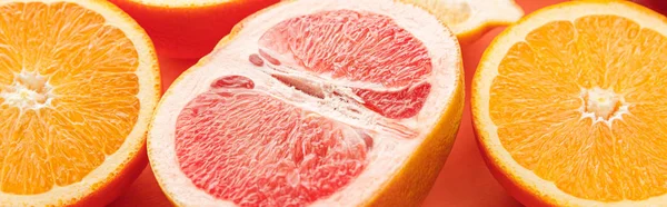 Цитрусовые половинки на оранжевом фоне, панорамный снимок — стоковое фото