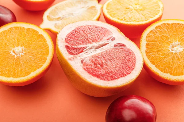 Enfoque selectivo de las mitades de cítricos y manzanas en naranja - foto de stock