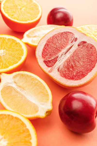 Metades de citrinos e maçãs sobre fundo laranja — Fotografia de Stock