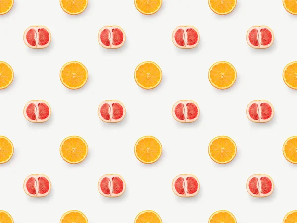Vista superior de las mitades de pomelos y rodajas de naranja sobre fondo blanco - foto de stock