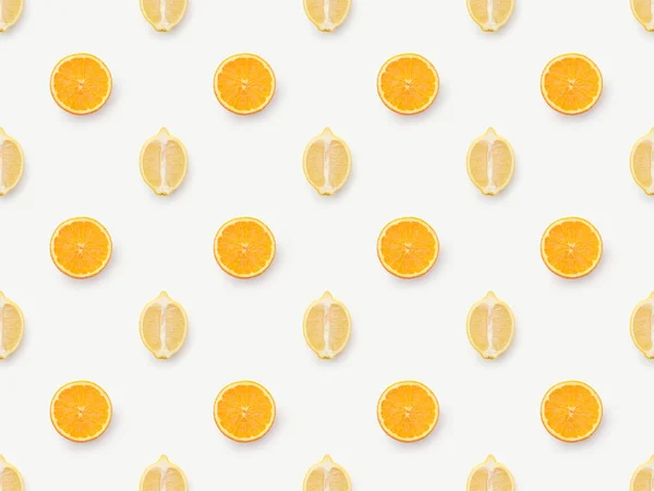 Vista superior de rodajas de naranja y mitades de limones sobre fondo blanco - foto de stock