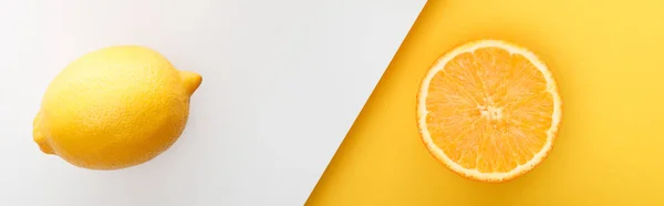 Top view of orange half and lemon on yellow and white background, panoramic shot — Stock Photo