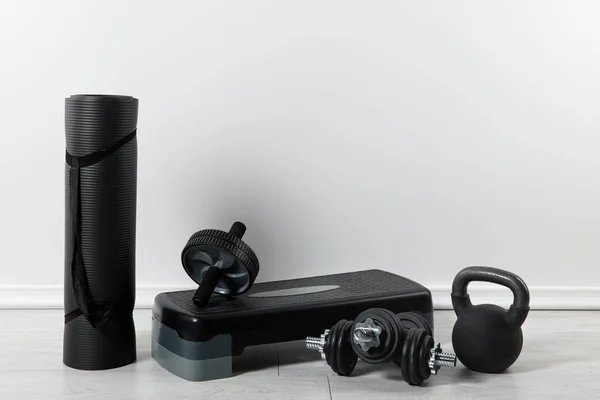 Alfombra de fitness negro, plataforma de paso y cosas deportivas en casa - foto de stock