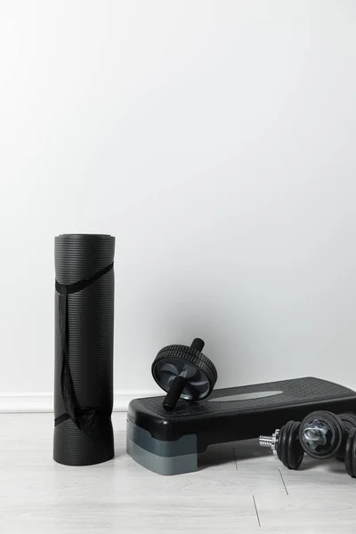 Black fitness mat and sports stuff on floor at home — Stock Photo