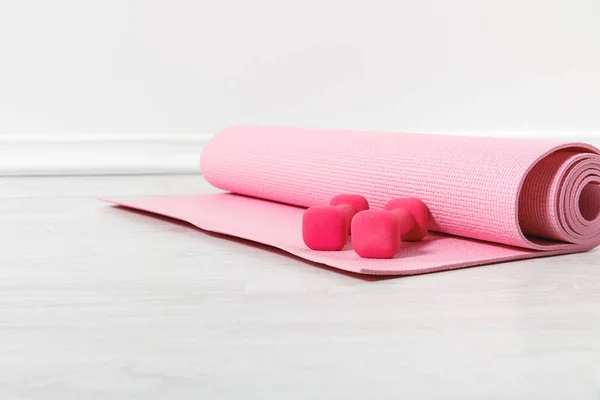 Alfombra de fitness y pesas de color rosa en el suelo — Stock Photo