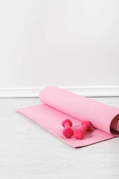 Alfombra de fitness y pesas de color rosa en el suelo — Stock Photo