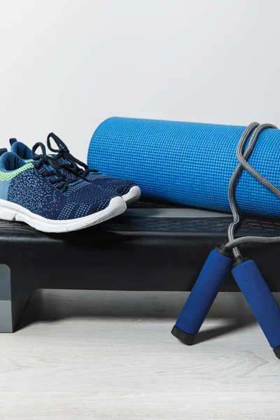 Step platform, fitness mat, skipping rope and sneakers — Stock Photo