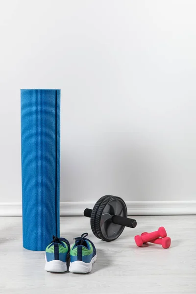 Tapetes de fitness e equipamentos esportivos no chão em casa — Fotografia de Stock