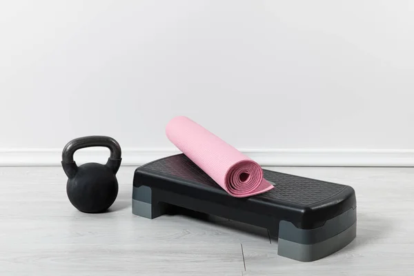 Plateforme step, kettlebell et tapis de fitness rose à la maison — Photo de stock