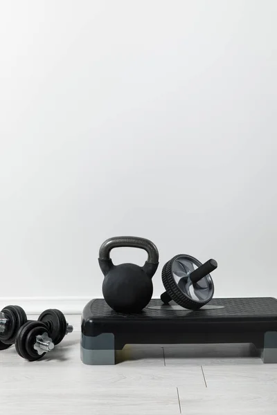 Step platform, dumbbells and kettlebell on floor at home — Stock Photo
