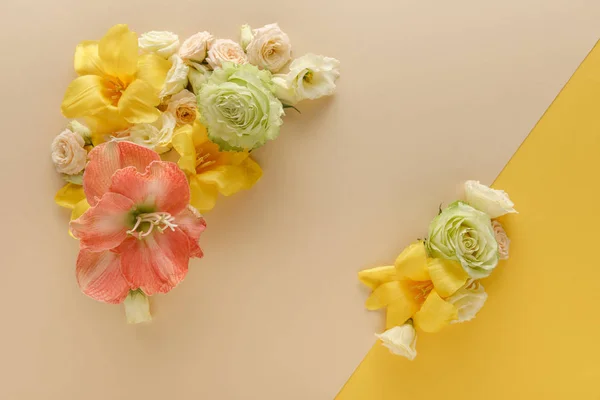 Vue de dessus des bouquets floraux printaniers sur fond beige et jaune — Photo de stock