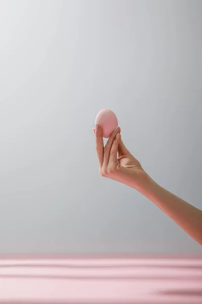 Partial view of woman holding chicken egg isolated on grey background — Stock Photo