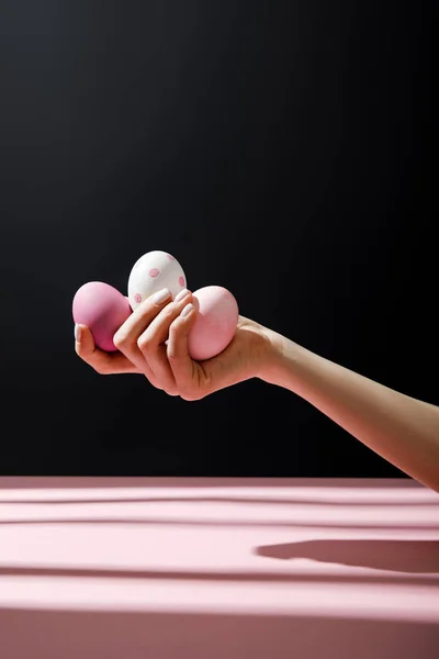 Vista recortada de una mujer sosteniendo huevos de pollo aislados sobre fondo negro - foto de stock