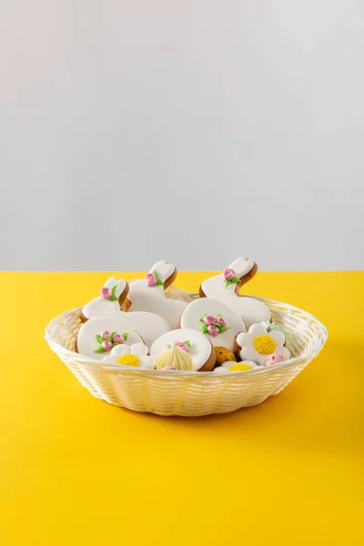 Deliciosas galletas en canasta de mimbre aisladas en gris y amarillo - foto de stock