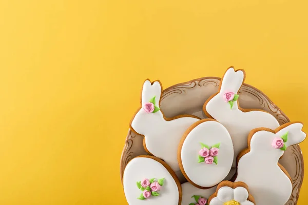 Vista superior del tazón con deliciosas galletas de Pascua sobre fondo amarillo - foto de stock