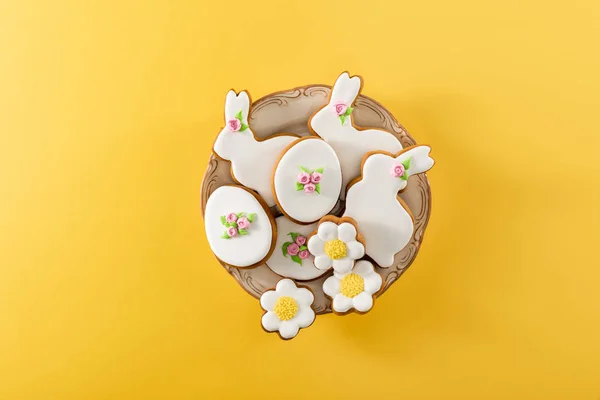 Top view of bowl with tasty easter cookies on yellow background — Stock Photo