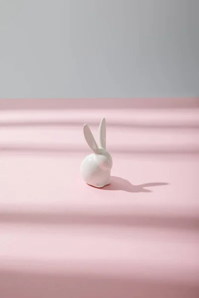 Белый декоративный кролик на розовом и сером — стоковое фото