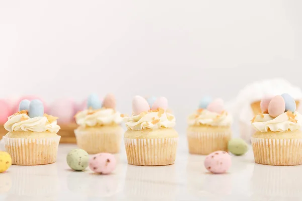 Focus selettivo di cupcake pasquali con uova di quaglia dipinte su sfondo grigio — Foto stock